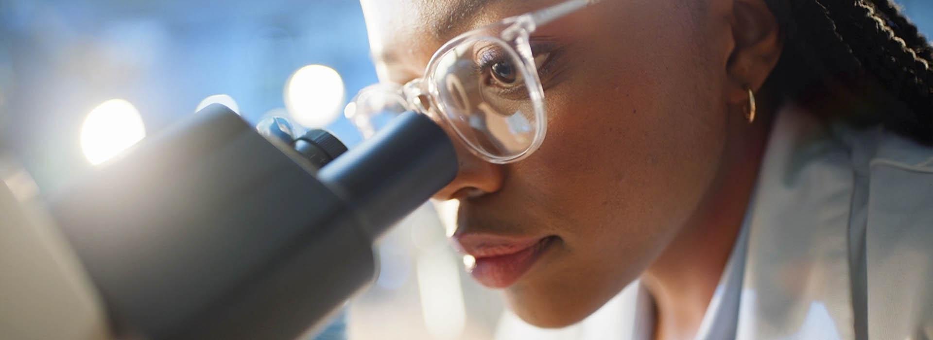 Woman looking into microscope